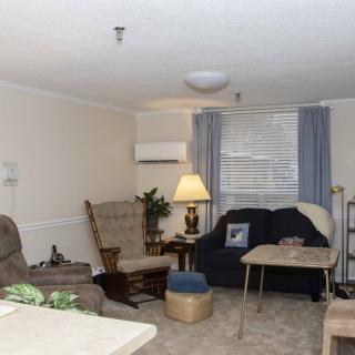 A cozy living room with comfortable seating, a lamp, and a small table.