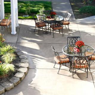 Outdoor patio area with metal tables and chairs on a sunny day.