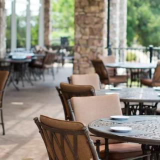 A peaceful outdoor patio with dining tables and chairs, perfect for a relaxing meal.