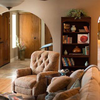 A cozy living room with comfortable armchairs and a well-organized bookshelf.