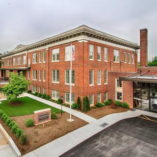 A brick school building with well-maintained landscaping and a modern entrance.