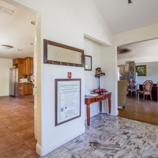 A cozy home interior featuring an entryway leading to a kitchen and living room with elegant furniture.