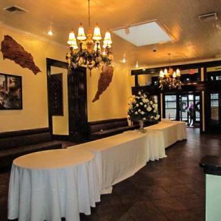 An elegant restaurant interior featuring chandeliers and decorated tables.