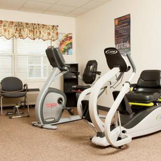 A small indoor gym room with exercise bikes and a desk area.