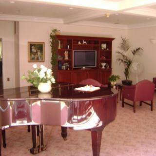 A cozy living room with a grand piano and elegant furnishings.