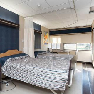 A hospital room with two beds and curtains.