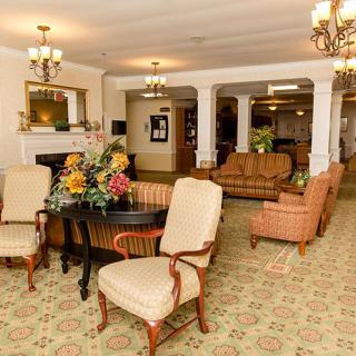 A warmly decorated hotel lobby with elegant furniture and floral arrangements.