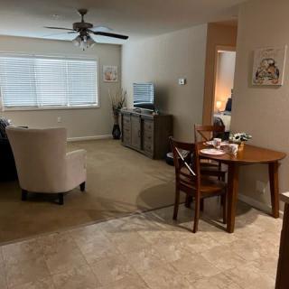 A cozy living room with a dining area, featuring a television and comfortable furniture.