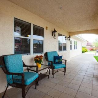A cozy patio area with blue cushioned chairs and a small table, perfect for relaxation.