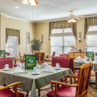A well-set dining area with tables and chairs, featuring elegant decor and natural lighting.