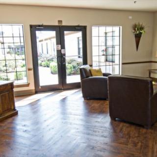 A spacious lobby area with chairs and large windows allowing natural light to fill the room.