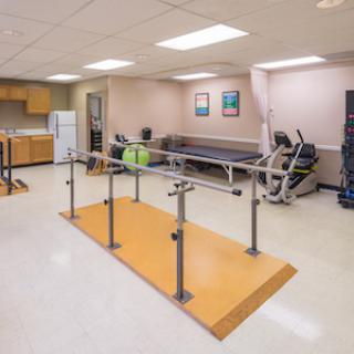 A rehabilitation center featuring parallel bars for physical therapy.