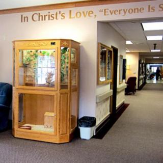 A hallway featuring a wooden display case and a quote on the wall.