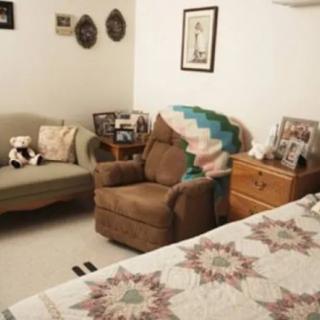 Cozy living room corner with an armchair, sofa, and decorative elements.