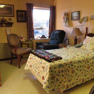 Cozy bedroom with floral bedding and comfortable seating arrangements.