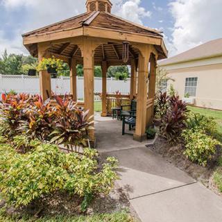A charming gazebo surrounded by lush plants in a well-maintained garden.