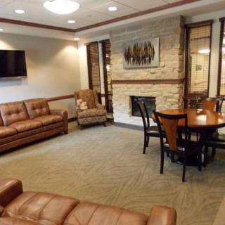 A cozy living room with sofas, a fireplace, and a dining table.