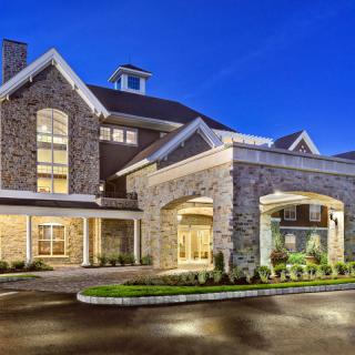 A beautifully lit building with a stone facade and welcoming entrance at night.