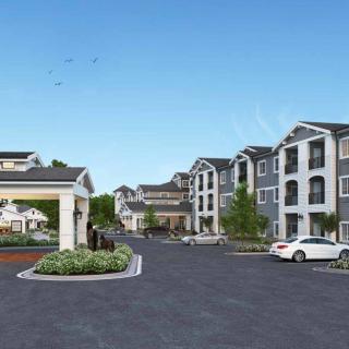 A modern apartment complex with landscaped surroundings and a parking area.