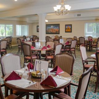 A well-arranged dining room with neatly set tables and elegant decor.