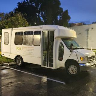 A white bus parked in a parking lot, ready for a new journey.