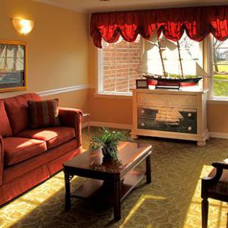A cozy living room with a sofa, coffee table, and a fireplace under bright natural light.