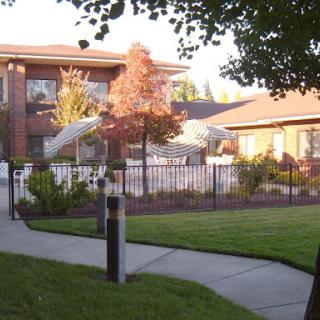 A well-maintained residential area featuring a building surrounded by greenery and a pathway.