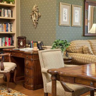 A traditional office interior with classic wooden furniture and a cozy seating area.