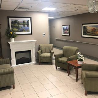 A cozy waiting area featuring comfortable green chairs and tasteful artwork.