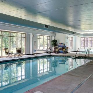 An inviting indoor swimming pool with large windows and seating areas.
