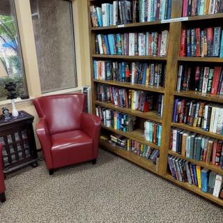 A cozy reading corner with red chairs and a bookshelf filled with books.