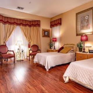 A cozy bedroom with twin beds, elegant curtains, and warm lighting.