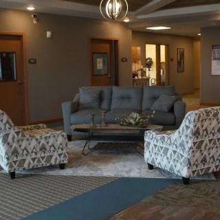 A cozy lobby area with a sofa and patterned armchairs arranged around a central table.
