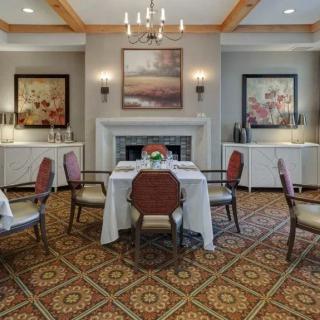 An elegantly decorated dining room featuring a fireplace and chandelier.