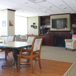 A cozy living room with comfortable seating, a television, and a dining table.