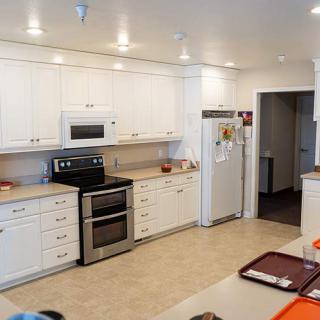 A modern kitchen with white cabinets, stainless steel appliances, and a spacious countertop.
