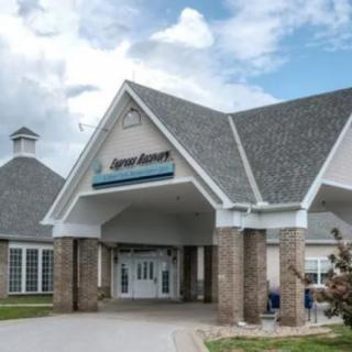 Entrance of a healthcare facility with a pitched roof and brick exterior.