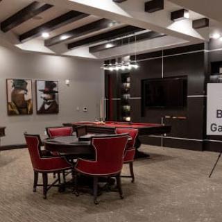 A stylish, modern game room featuring a pool table and red chairs.