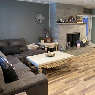 A cozy living room with a sectional couch, coffee table, and a fireplace.
