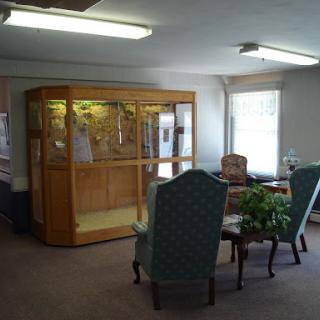 A cozy living room space featuring comfortable seating and a display case.
