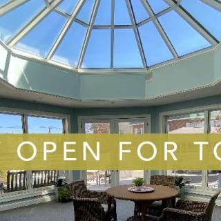 Bright sunroom with a glass ceiling and comfortable seating.
