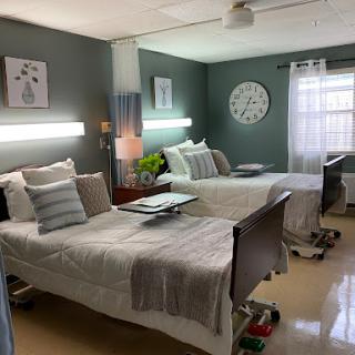 A comfortable shared patient room in a healthcare facility, featuring two beds and a calming color scheme.