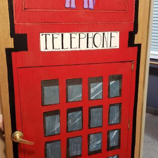 A door decorated to resemble a classic red British telephone booth.