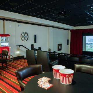 A cozy home theater setup with a large projector screen, comfortable seating, and a popcorn machine.