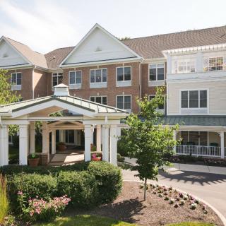 A residential building with a landscaped entrance on a sunny day.