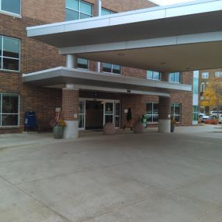 The entrance to a modern brick hospital building.