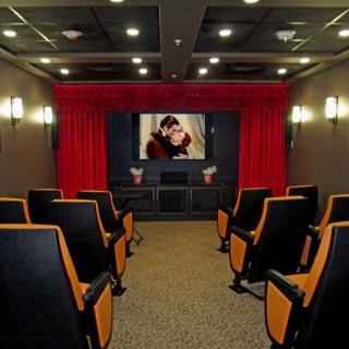 A cozy home theater with comfortable seating and a large movie screen.