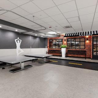 A contemporary dance studio featuring a minimalist design and a cozy lounge area.