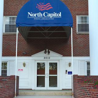 Entrance of a building with a blue awning labeled 'North Capitol'.