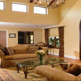 A spacious living room with elegant furniture and warm lighting.